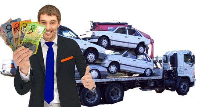 Man in a suit holding cash with stacked cars on a tow truck